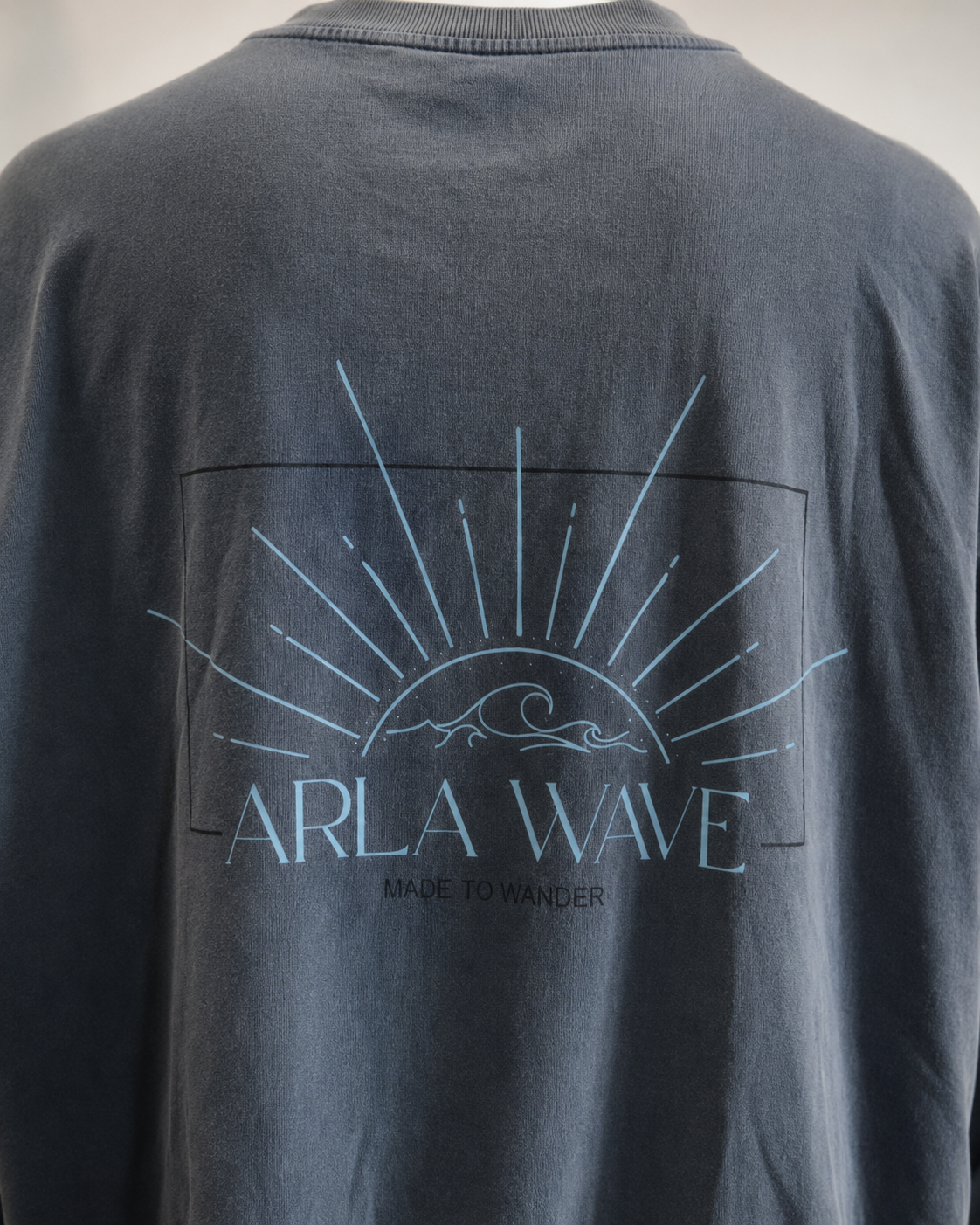 Arla Wave navy oversized long sleeve shirt back view on model, close up, large light blue logo with sun and waves