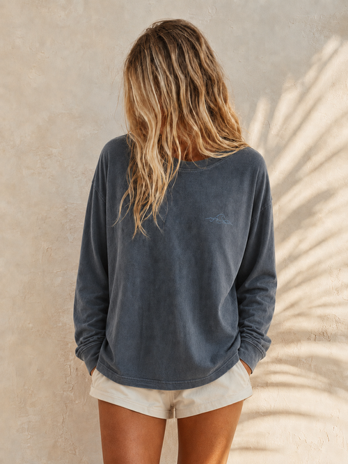 Arla Wave navy oversized long sleeve shirt front view, small light blue wave logo on left side of feminine models chest